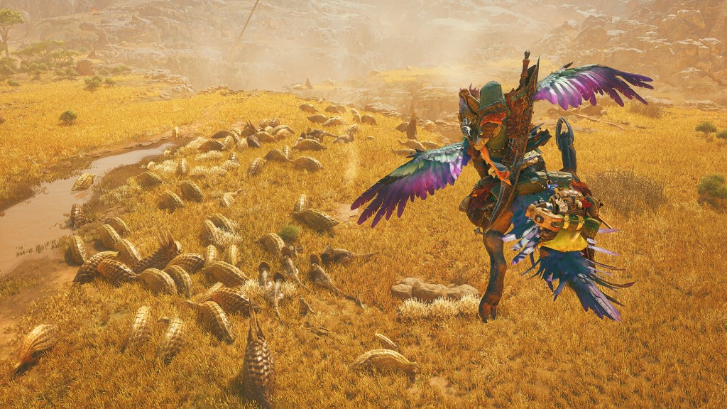 A promotional screenshot from Monster Hunter Wilds. A titular monster hunter and their feline companion ride on a winged dinosaur. They glide over a herd of other indigenous wildlife.